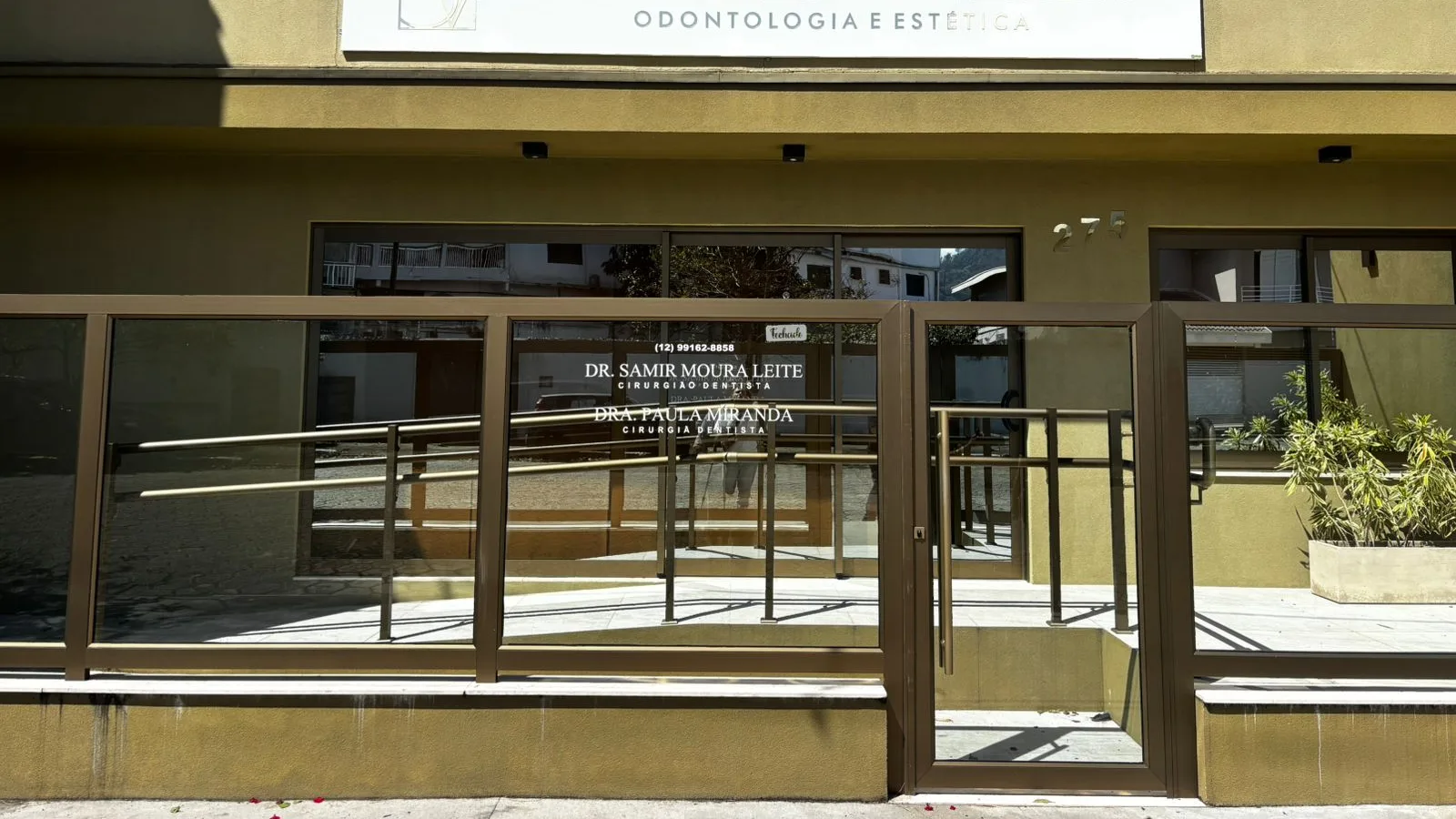 Fachada da Odonto Vitallis na Av. Rio de Janeiro, 275: placa branca com o logo, porta de vidro e rampa de acesso com corrimão dourado